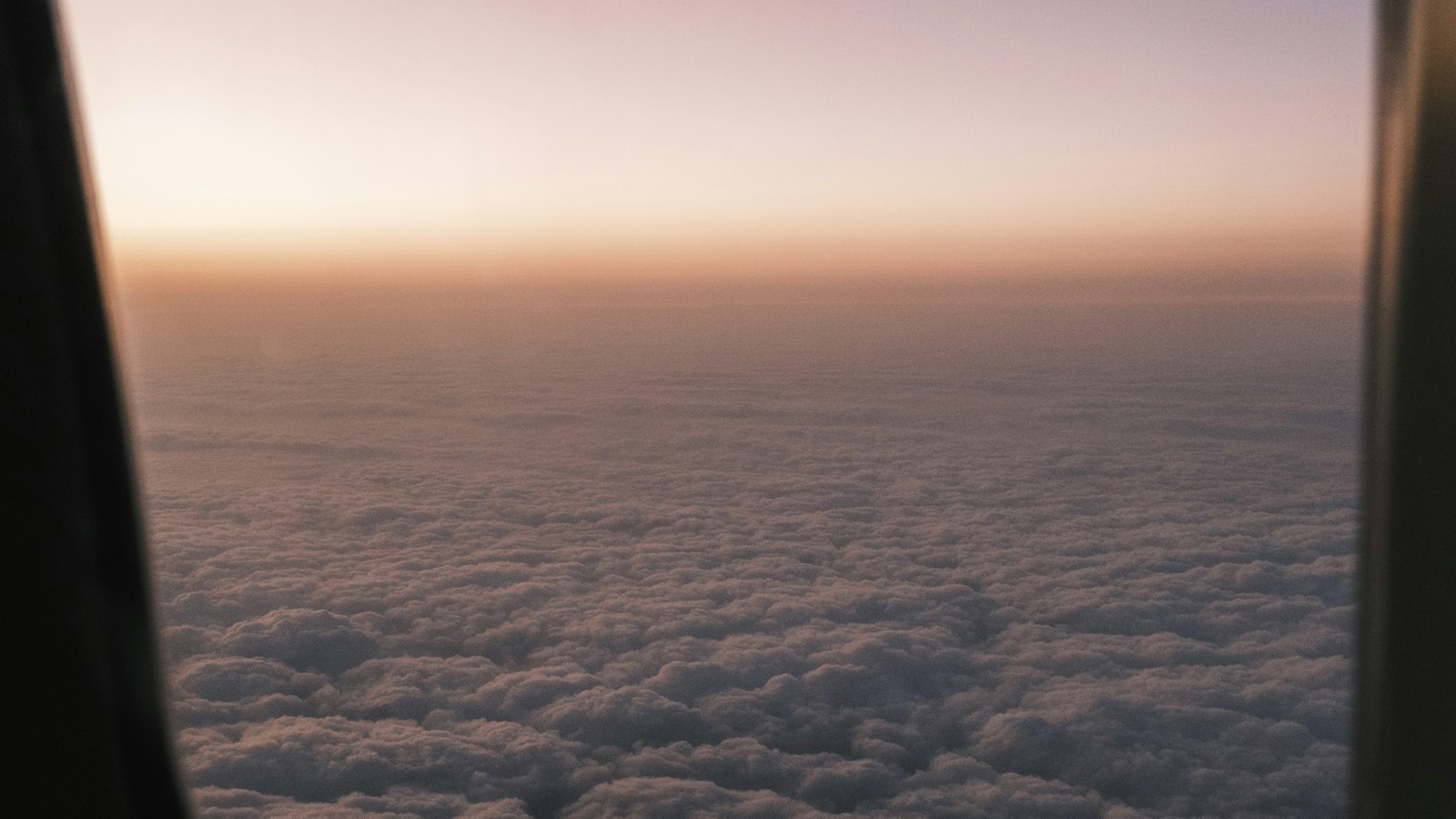 飛行機の窓から見える夕暮れの雲
